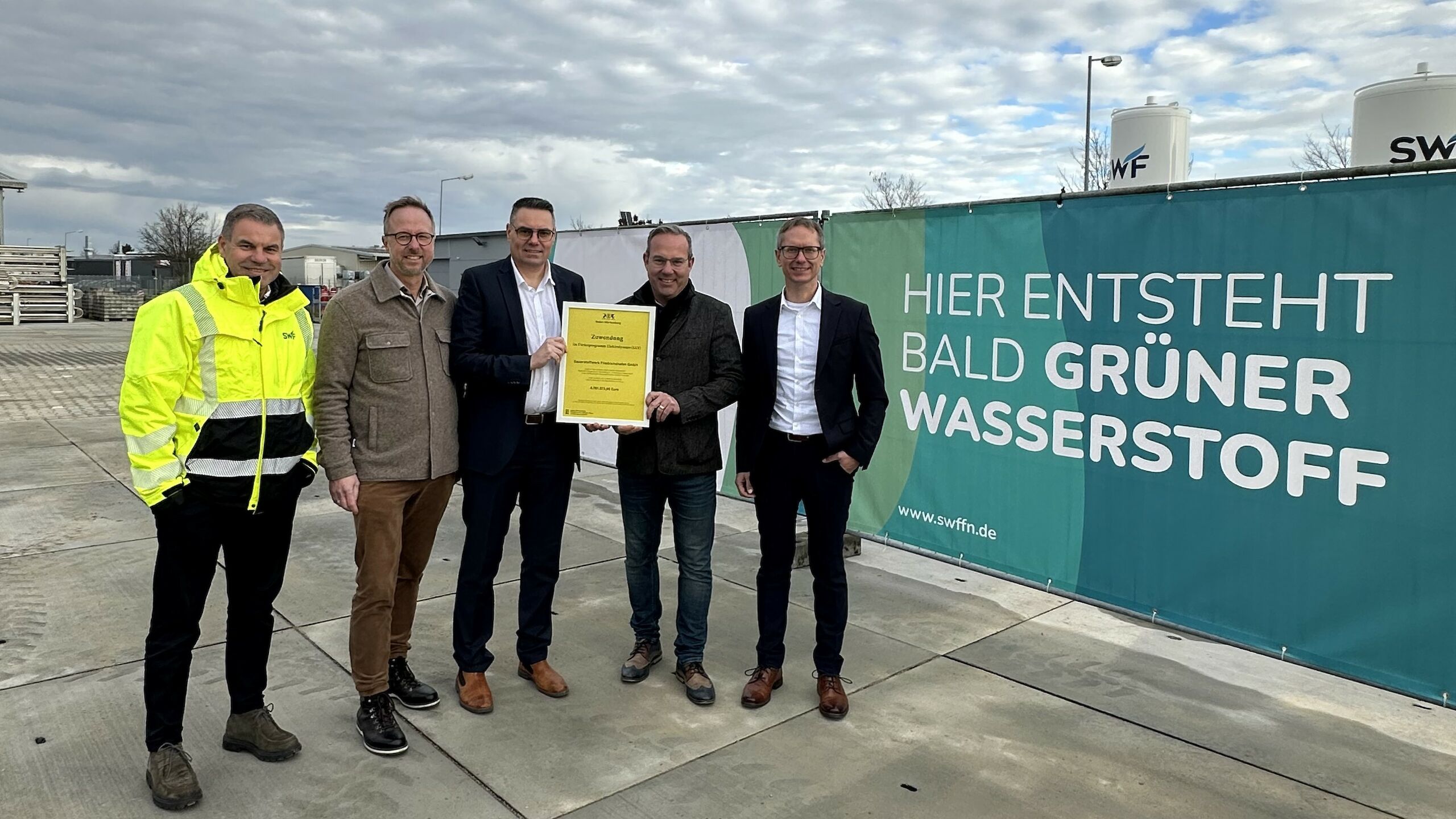 Stefan Wieder (SWF-Werksleiter Aitrach), Thomas Kellenberger (Bürgermeister Aitrach), Günther Haag (Geschäftsführer), Raimund Haser (Mitglied des Landtags Baden-Württemberg) und Oliver Fuchs (Leiter Unternehmensstrategie) am künftigen SWF-Wasserstoffkompetenzzentrum in Aitrach-Ferthofen