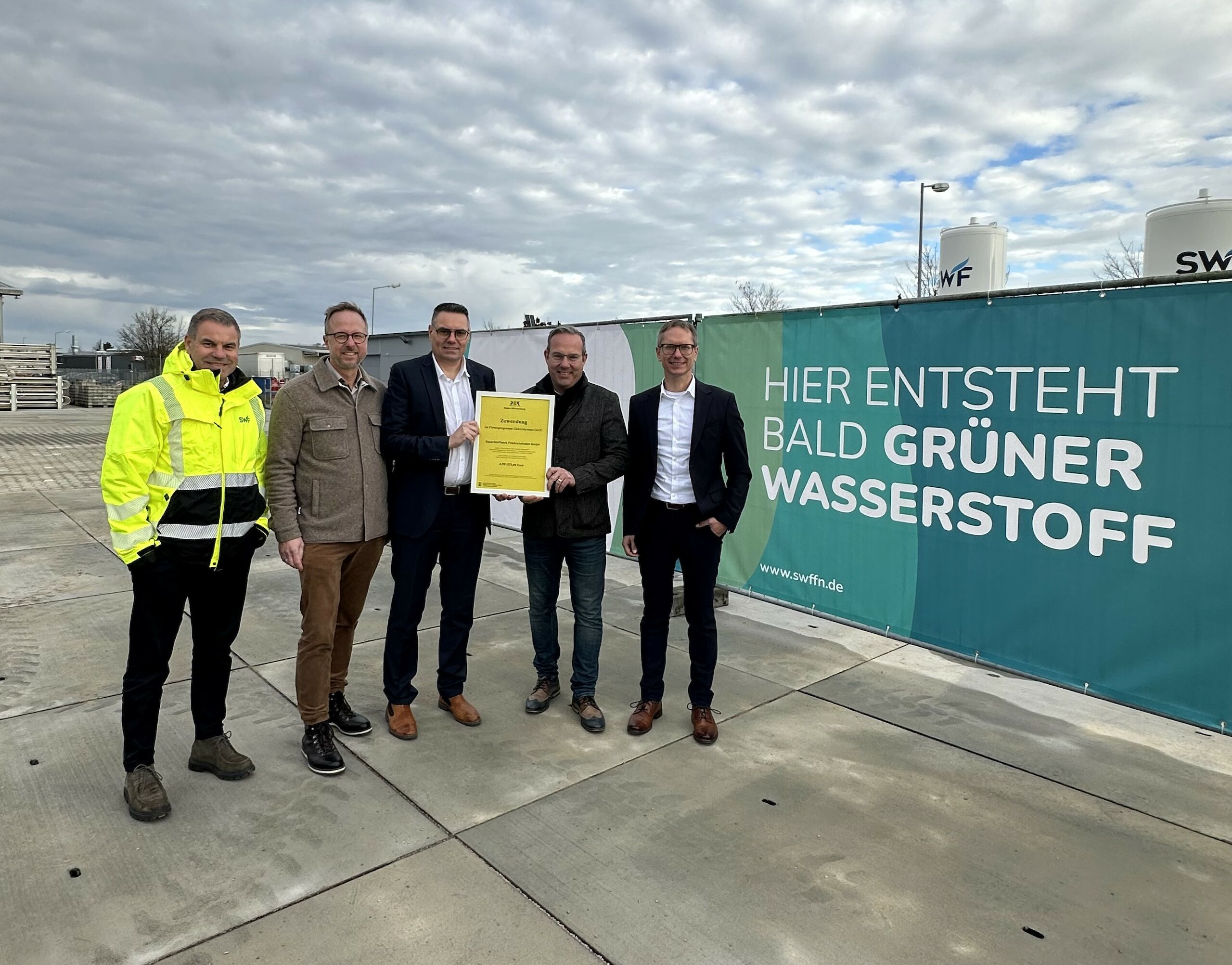Stefan Wieder (SWF-Werksleiter Aitrach), Thomas Kellenberger (Bürgermeister Aitrach), Günther Haag (Geschäftsführer), Raimund Haser (Mitglied des Landtags Baden-Württemberg) und Oliver Fuchs (Leiter Unternehmensstrategie) am künftigen SWF-Wasserstoffkompetenzzentrum in Aitrach-Ferthofen